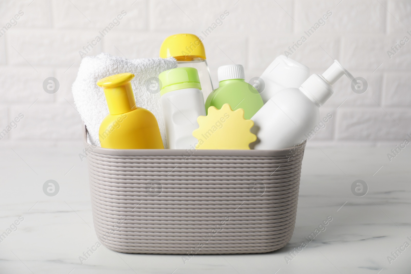 Photo of Many different baby bathroom necessities on table near brick wall