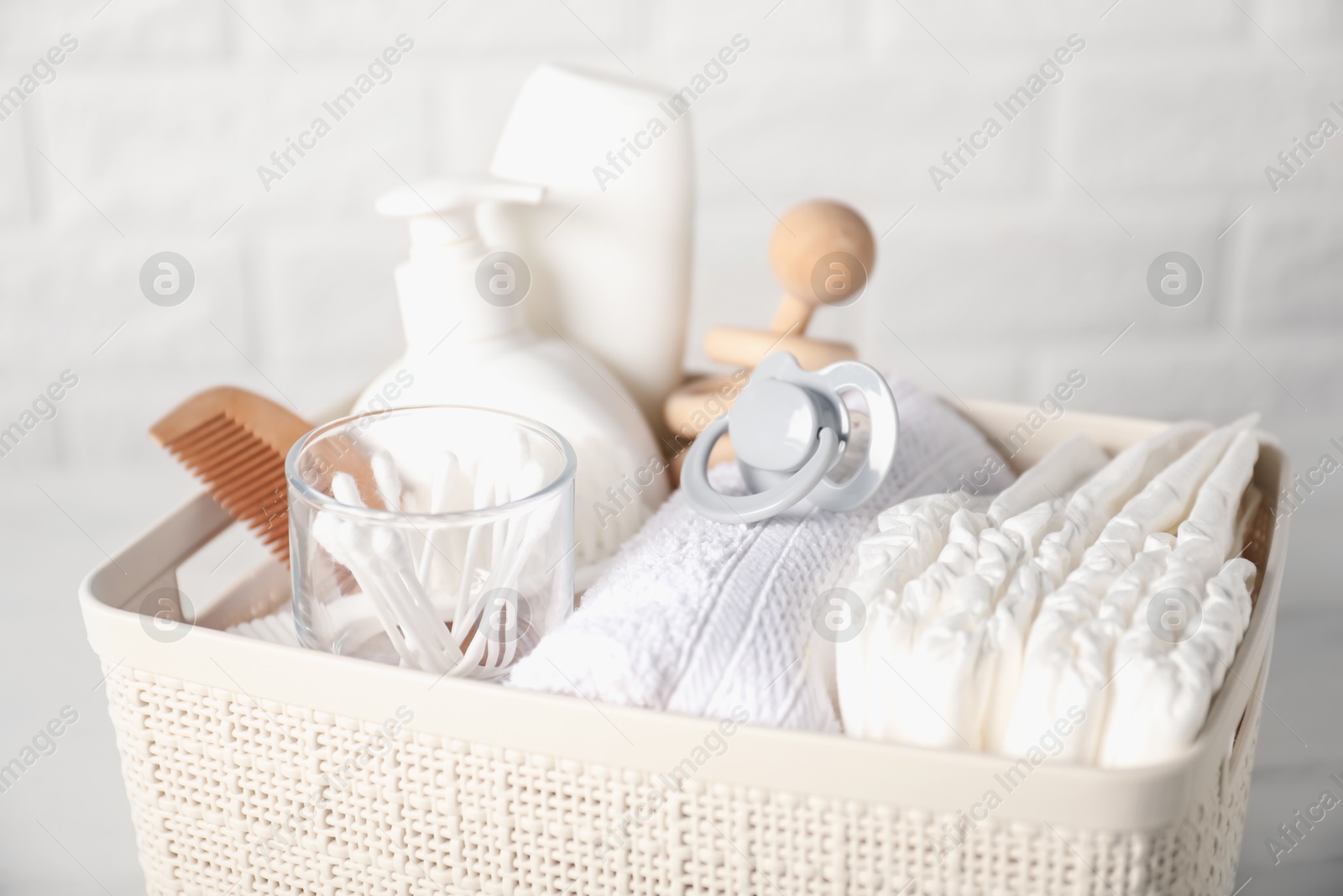 Photo of Many different baby accessories on table near brick wall, closeup