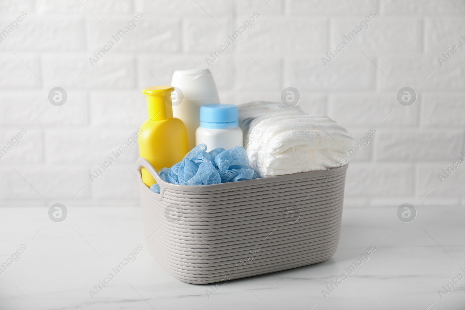 Photo of Many different baby bathroom necessities on table near brick wall