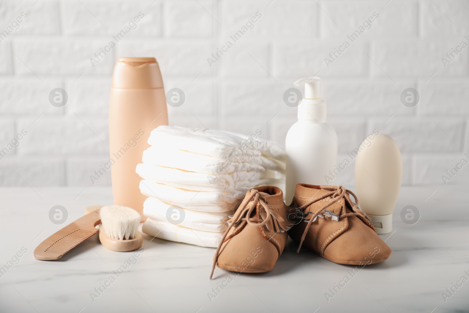 Photo of Many different baby accessories on table near brick wall