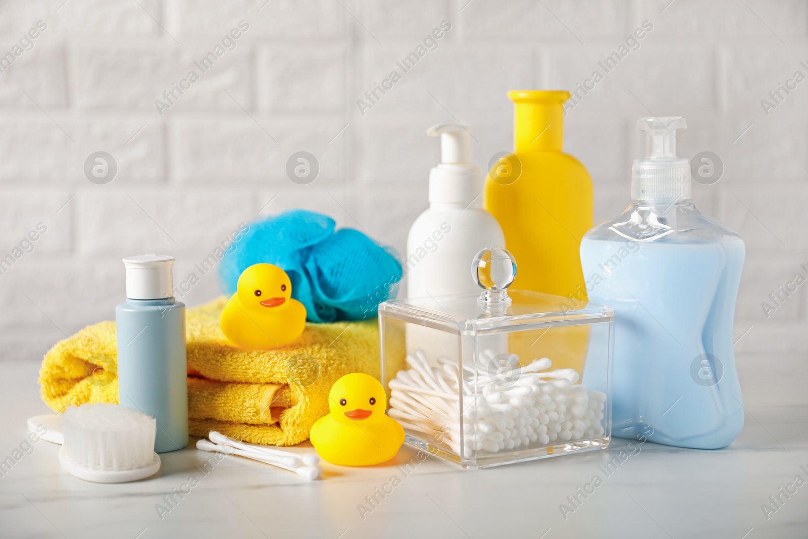 Photo of Many different baby bathroom necessities on table near brick wall