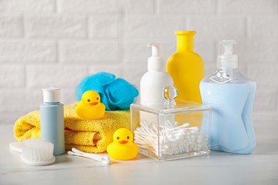 Photo of Many different baby bathroom necessities on table near brick wall