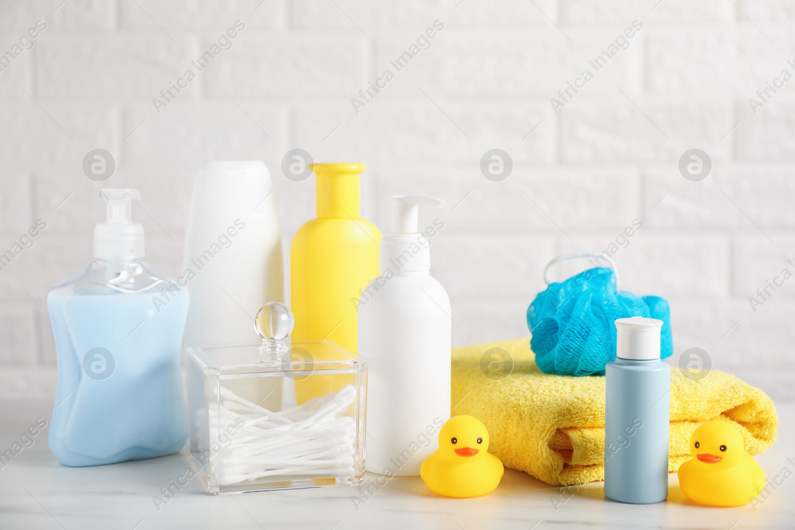 Photo of Many different baby bathroom necessities on table near brick wall