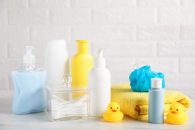 Photo of Many different baby bathroom necessities on table near brick wall