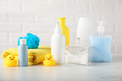 Photo of Many different baby bathroom necessities on table near brick wall