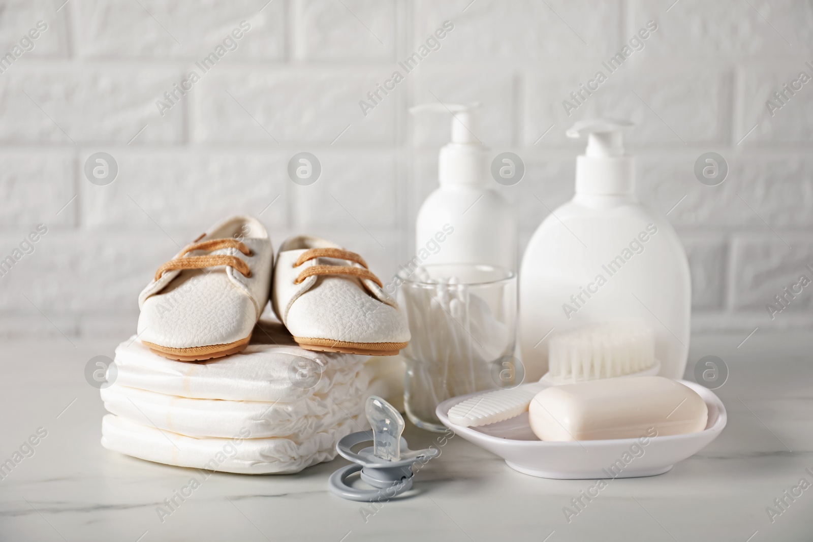 Photo of Many different baby accessories on table near brick wall