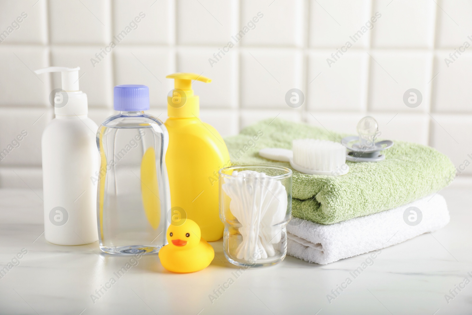 Photo of Many different baby bathroom necessities on table near tiled wall