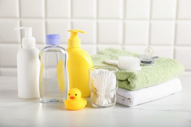 Photo of Many different baby bathroom necessities on table near tiled wall