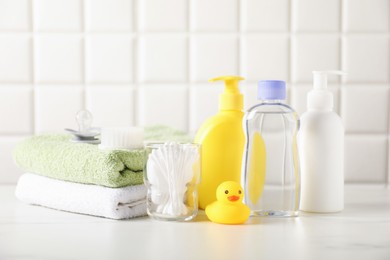 Photo of Many different baby bathroom necessities on table near tiled wall