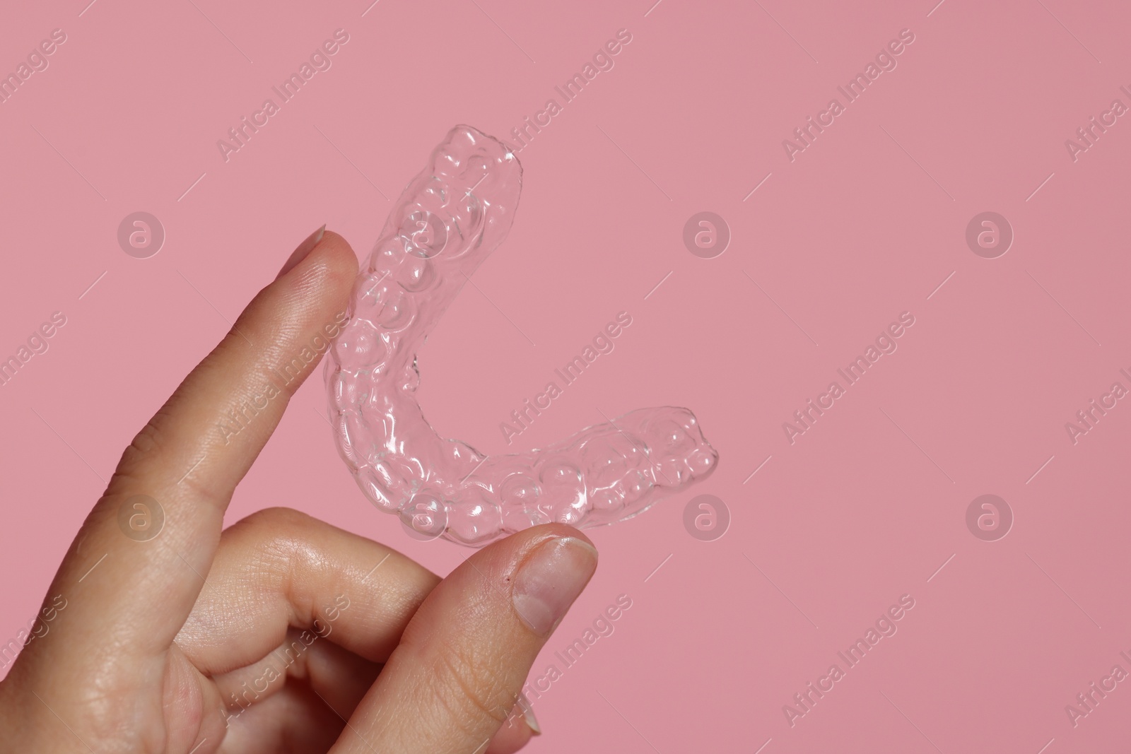 Woman with dental aligner on pink background, closeup Photo of Woman with dental aligner on pink background, closeup