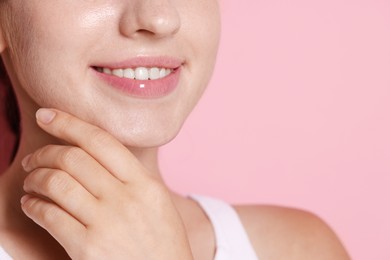 Photo of Smiling woman after dental aligners treatment on pink background, closeup. Space for text