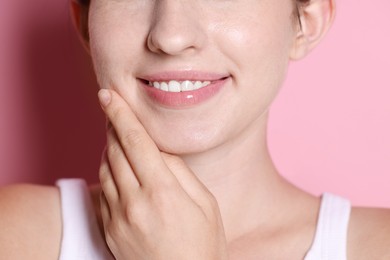 Photo of Smiling woman after dental aligners treatment on pink background, closeup