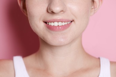 Photo of Smiling woman after dental aligners treatment on pink background, closeup