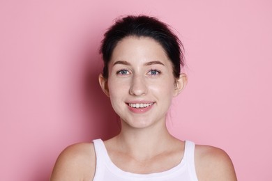 Photo of Portrait of smiling woman after dental aligners treatment on pink background