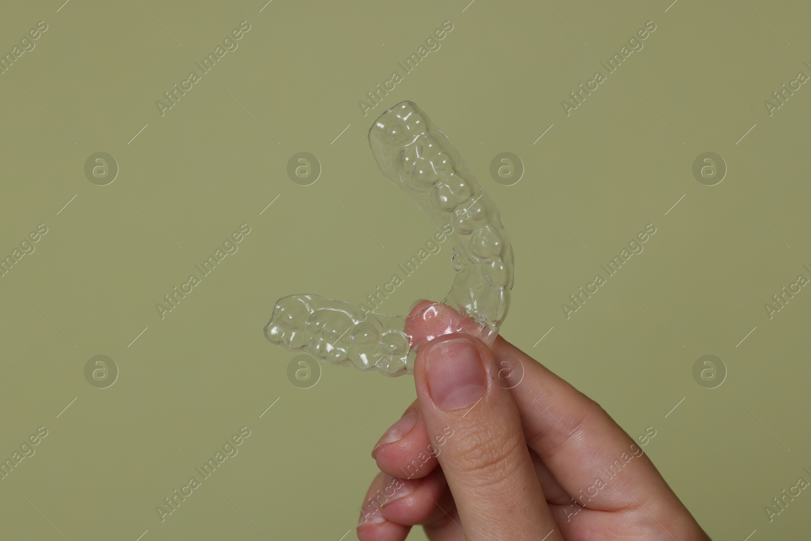 Woman with dental aligner on green background, closeup Photo of Woman with dental aligner on green background, closeup