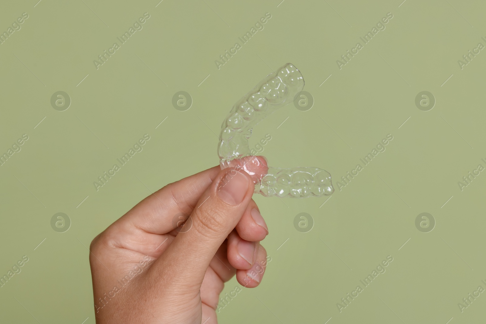 Woman with dental aligner on green background, closeup Photo of Woman with dental aligner on green background, closeup