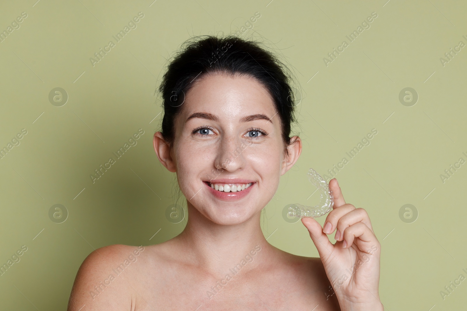 Portrait of smiling woman with dental aligner on green background, closeup Photo of Portrait of smiling woman with dental aligner on green background, closeup
