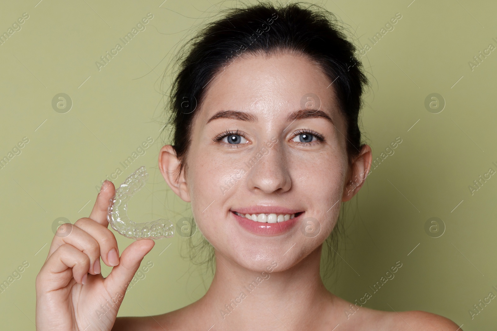 Portrait of smiling woman with dental aligner on green background, closeup Photo of Portrait of smiling woman with dental aligner on green background, closeup