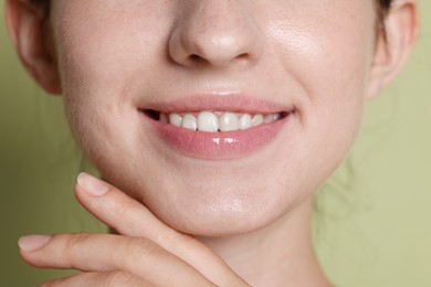 Photo of Smiling woman after dental aligners treatment on green background, closeup