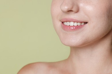 Photo of Smiling woman after dental aligners treatment on green background, closeup. Space for text