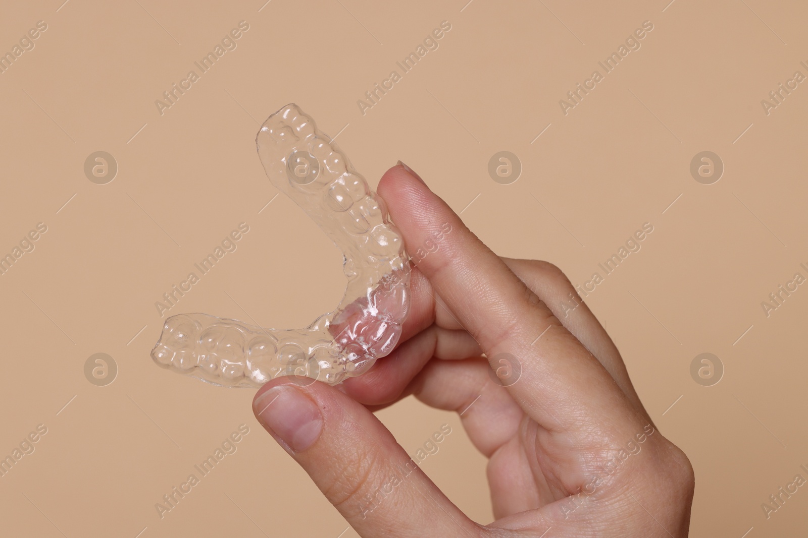 Woman with dental aligner on beige background, closeup Photo of Woman with dental aligner on beige background, closeup