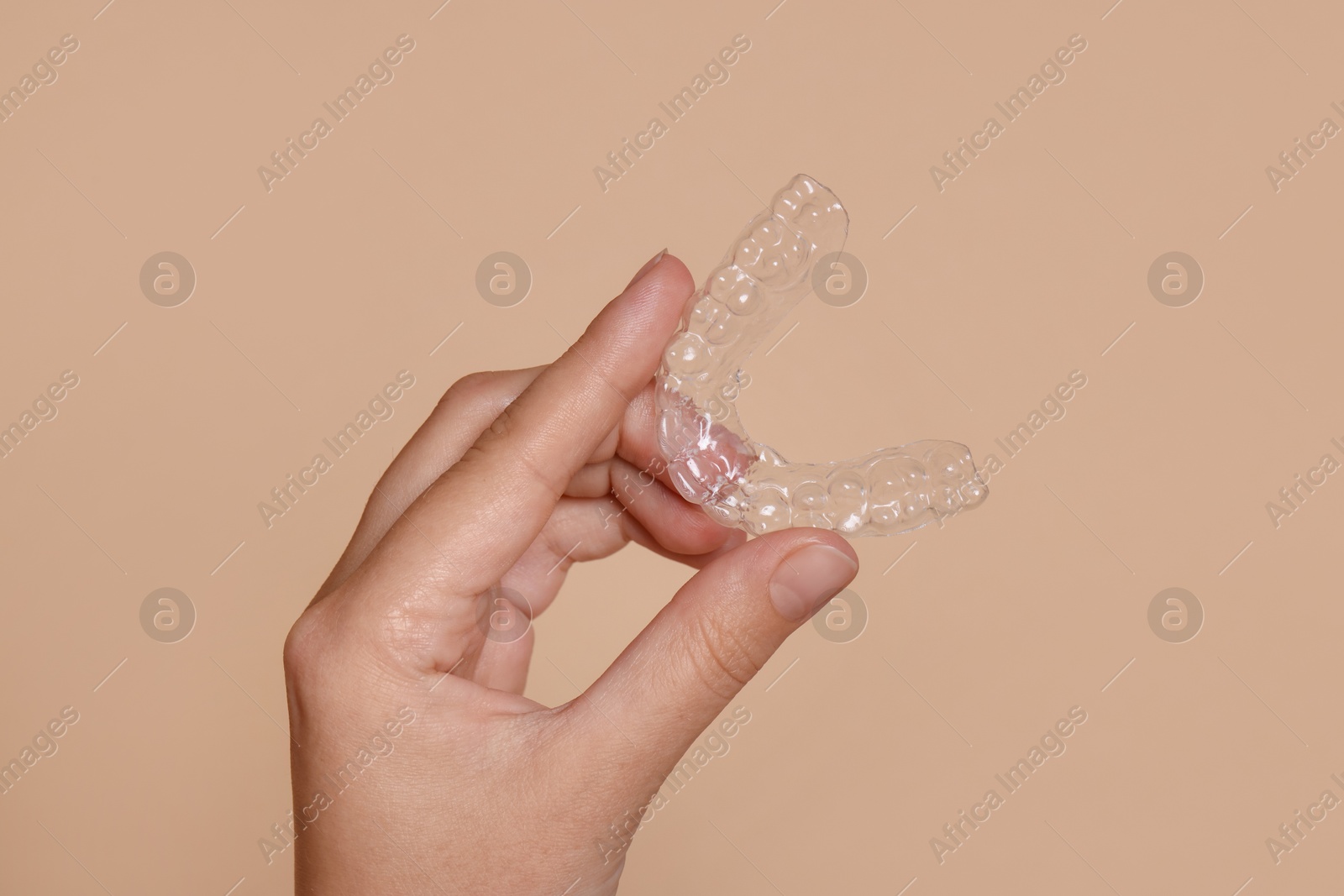 Woman with dental aligner on beige background, closeup Photo of Woman with dental aligner on beige background, closeup