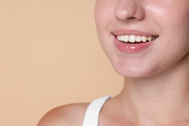 Photo of Smiling woman after dental aligners treatment on beige background, closeup. Space for text
