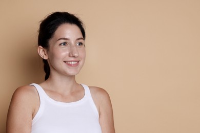 Photo of Smiling woman after dental aligners treatment on beige background. Space for text