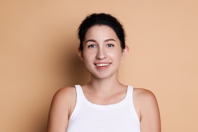 Photo of Portrait of smiling woman after dental aligners treatment on beige background