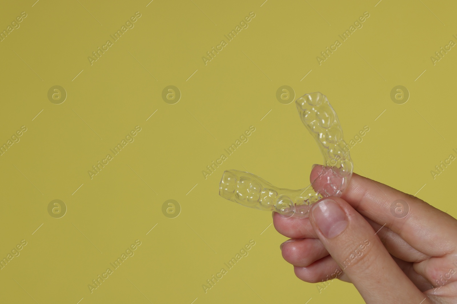 Woman with dental aligner on lime green background, closeup. Space for text Photo of Woman with dental aligner on lime green background, closeup. Space for text