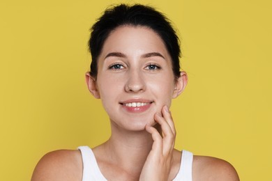 Photo of Portrait of smiling woman after dental aligners treatment on yellow background