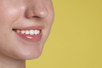 Photo of Smiling woman after dental aligners treatment on yellow background, closeup. Space for text