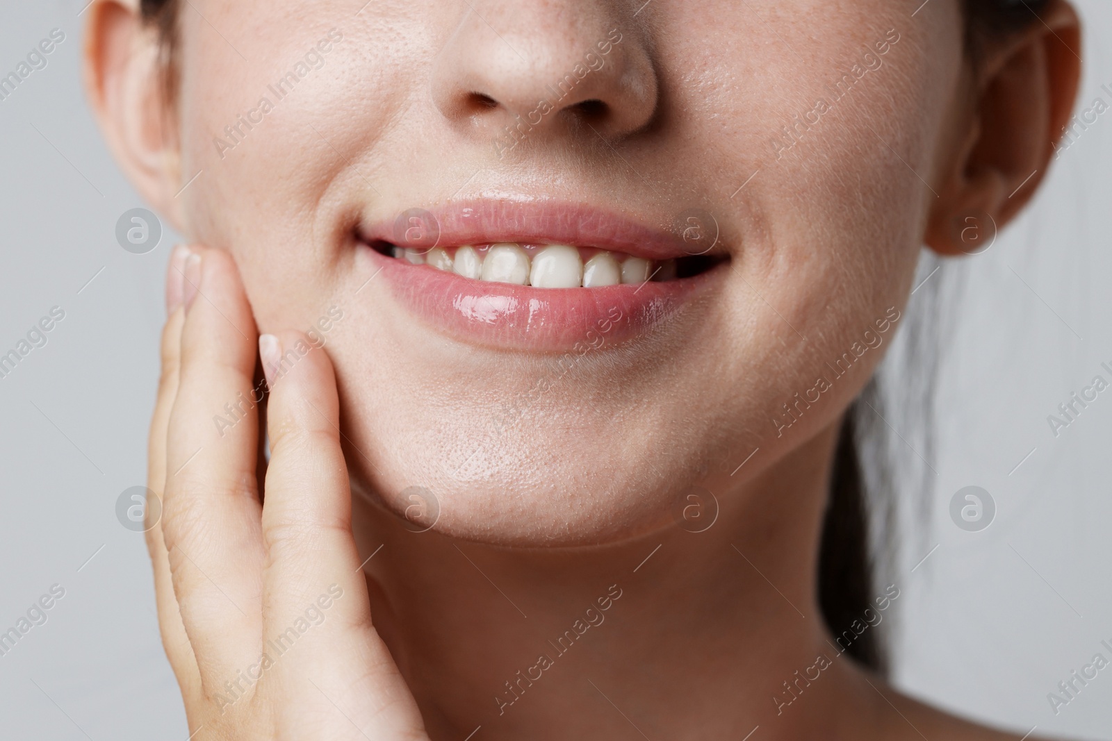 Smiling woman after dental aligners treatment on grey background, closeup Photo of Smiling woman after dental aligners treatment on grey background, closeup