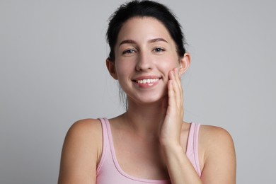 Photo of Portrait of smiling woman after dental aligners treatment on grey background