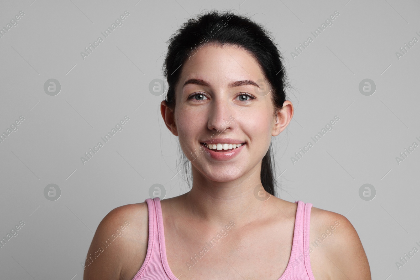 Portrait of smiling woman after dental aligners treatment on grey background Photo of Portrait of smiling woman after dental aligners treatment on grey background