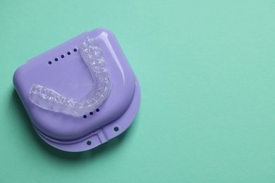 Photo of Clear aligner and retainer case on turquoise background, top view. Space for text