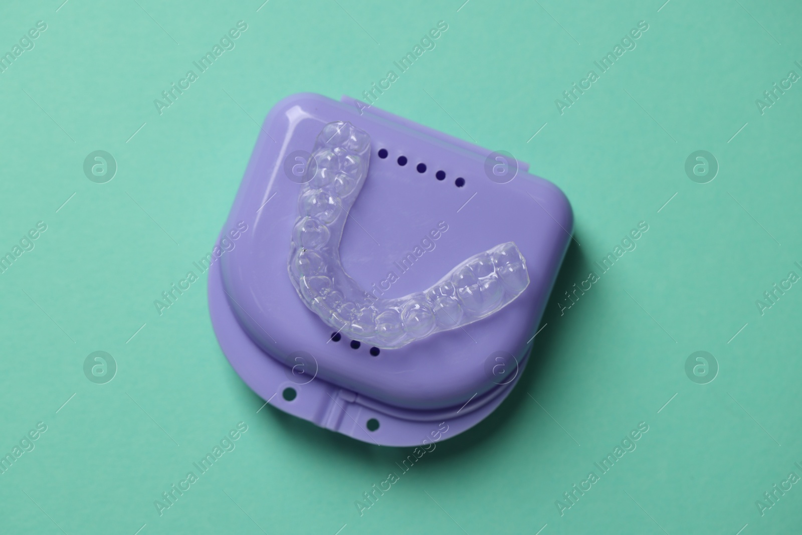 Clear aligner and retainer case on turquoise background, top view Photo of Clear aligner and retainer case on turquoise background, top view
