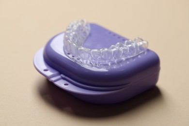 Photo of Clear aligner and retainer case on beige background, closeup
