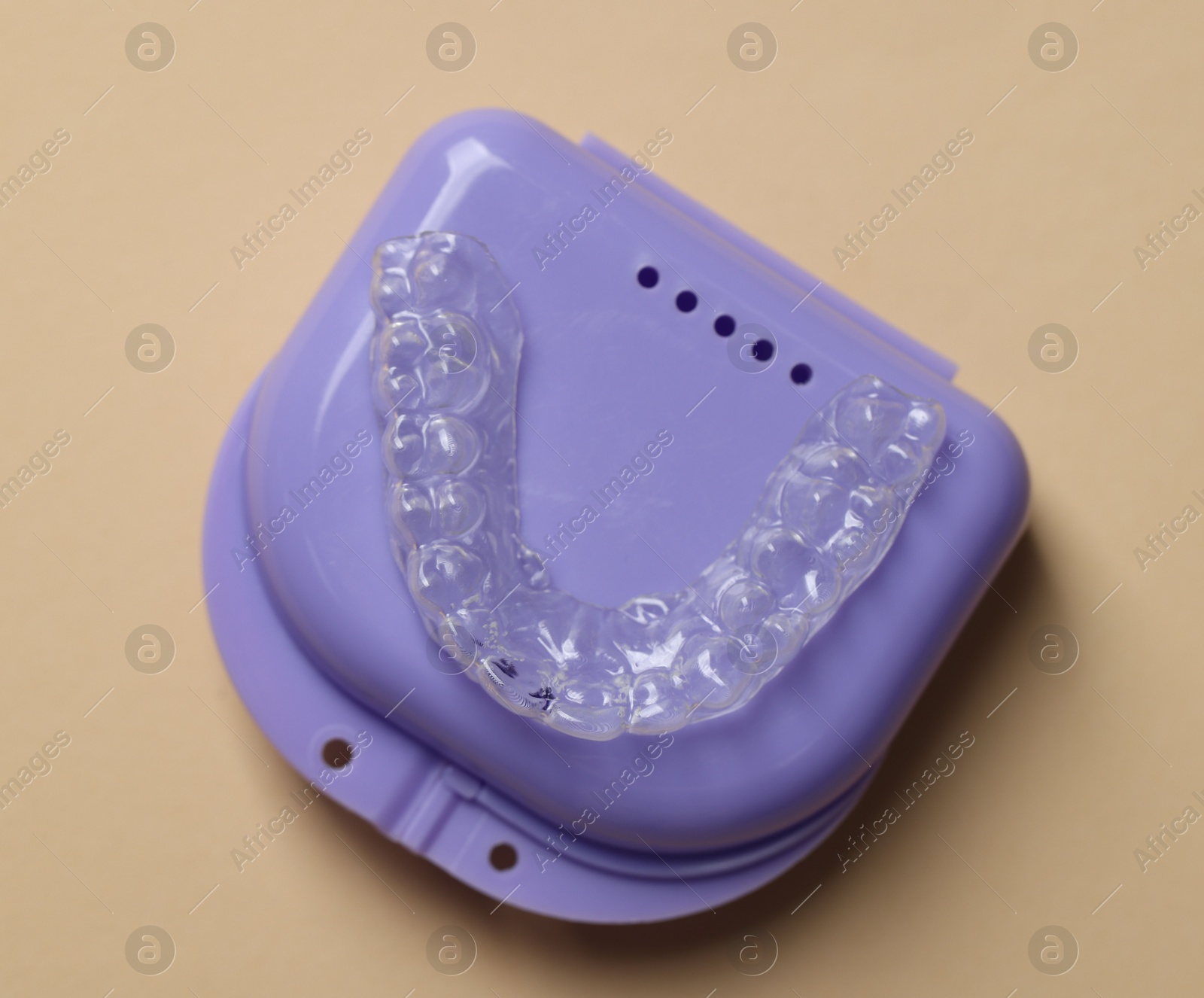 Clear aligner in retainer case on beige background, top view Photo of Clear aligner in retainer case on beige background, top view