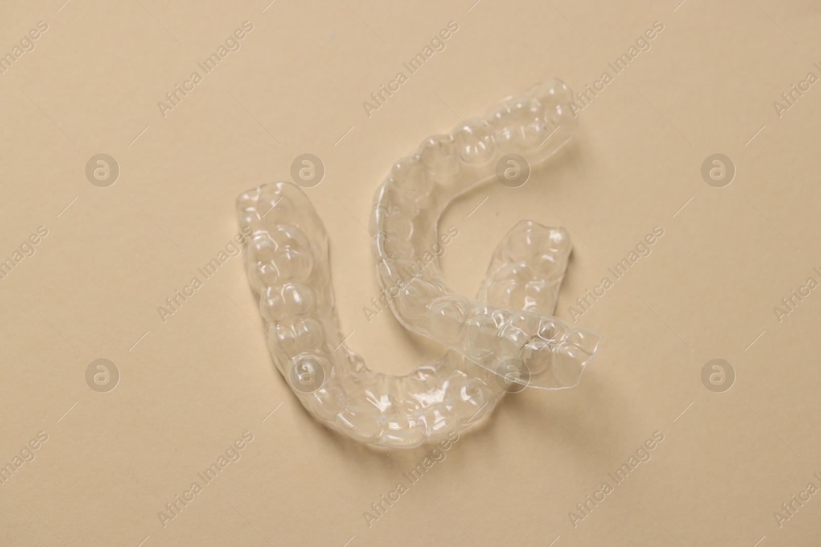 Clear aligners on beige background, top view Photo of Clear aligners on beige background, top view