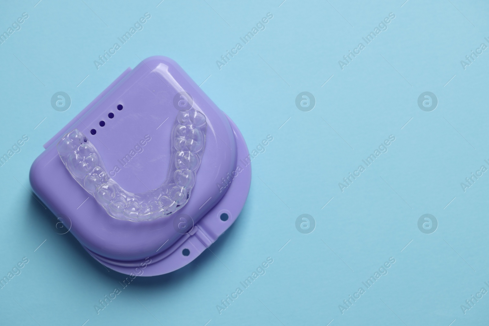One clear aligner and retainer case on light blue background, top view. Space for text Photo of One clear aligner and retainer case on light blue background, top view. Space for text