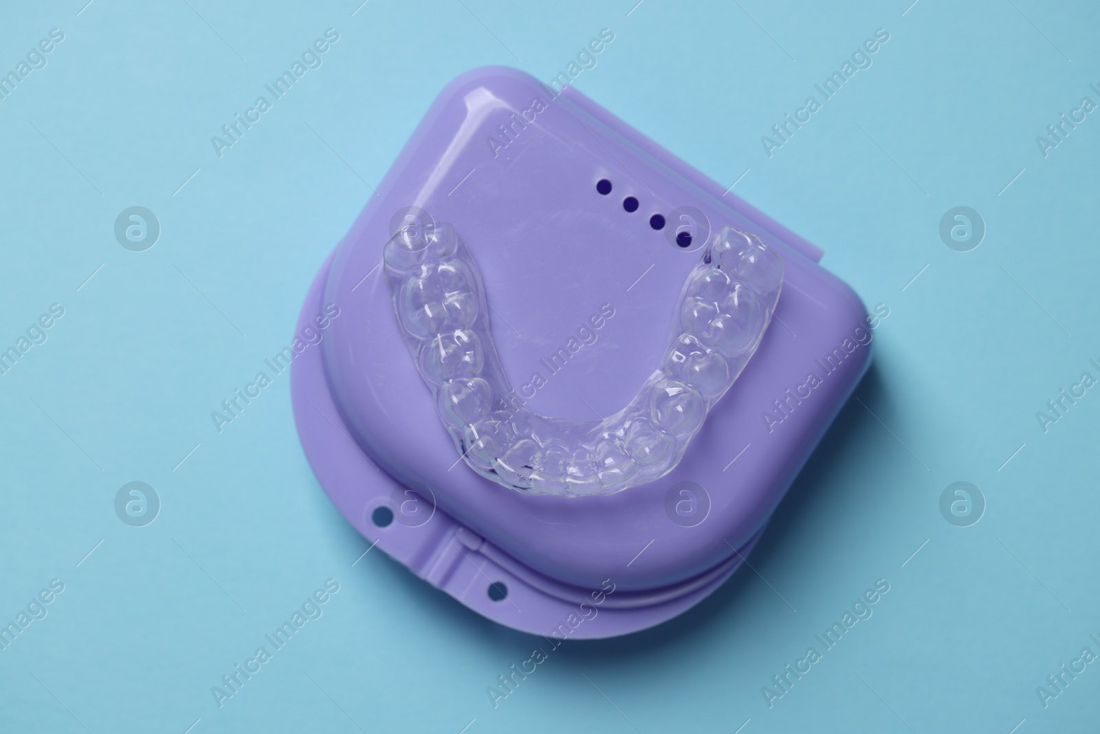 One clear aligner and retainer case on light blue background, top view Photo of One clear aligner and retainer case on light blue background, top view