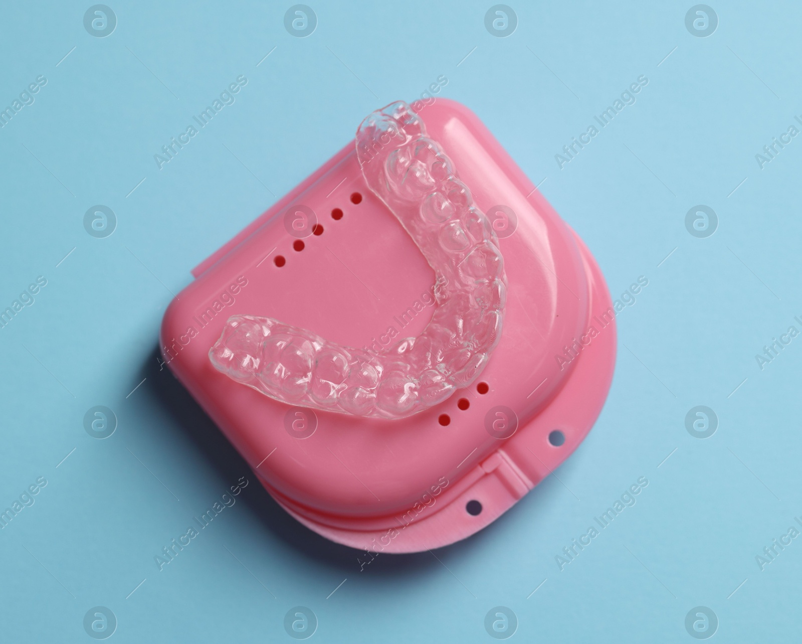 One clear aligner and retainer case on light blue background, top view Photo of One clear aligner and retainer case on light blue background, top view