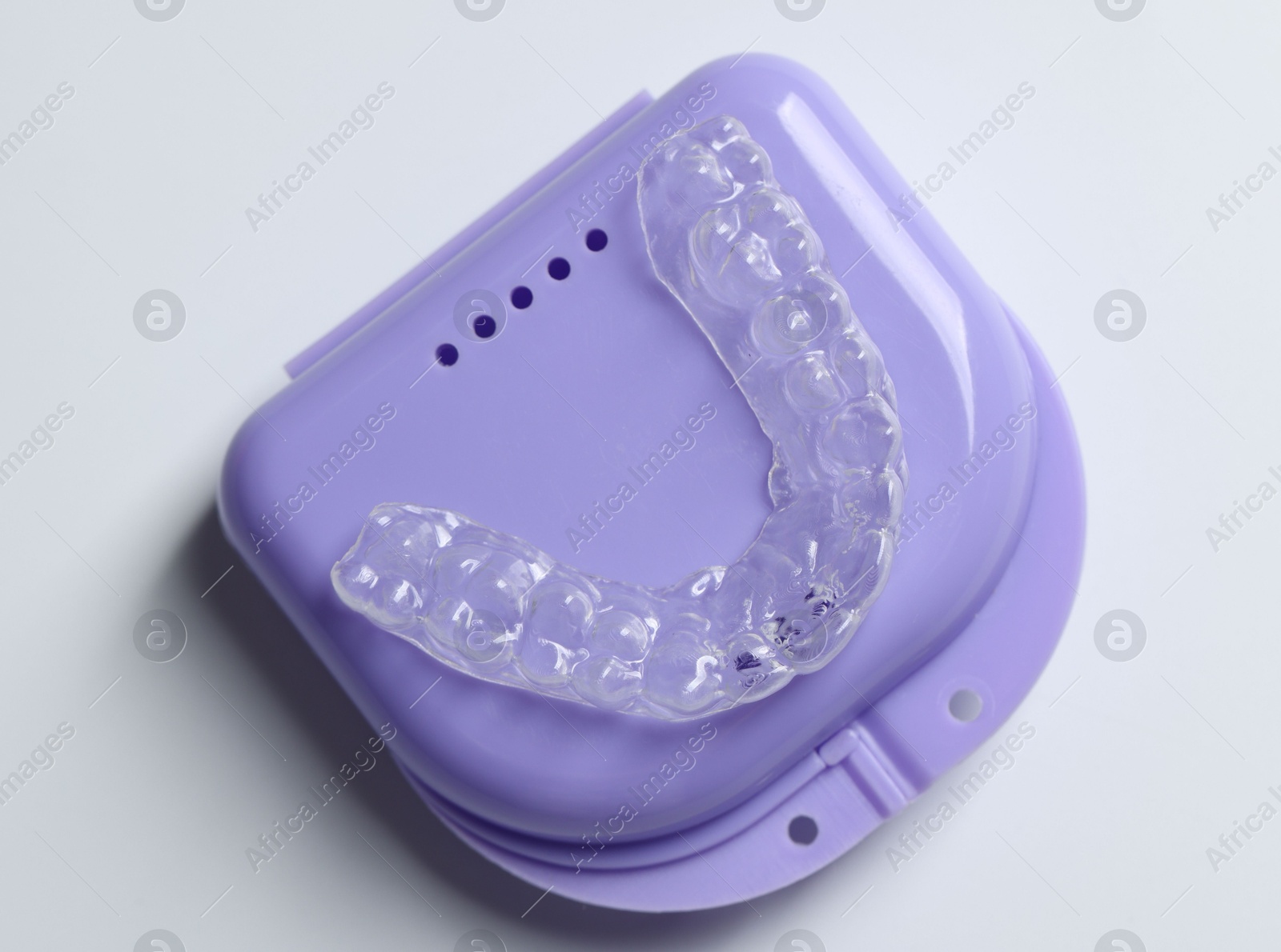 One clear aligner and retainer case on light grey background, top view Photo of One clear aligner and retainer case on light grey background, top view