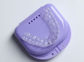 Photo of One clear aligner and retainer case on light grey background, top view