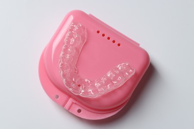 Photo of One clear aligner and retainer case on light grey background, top view