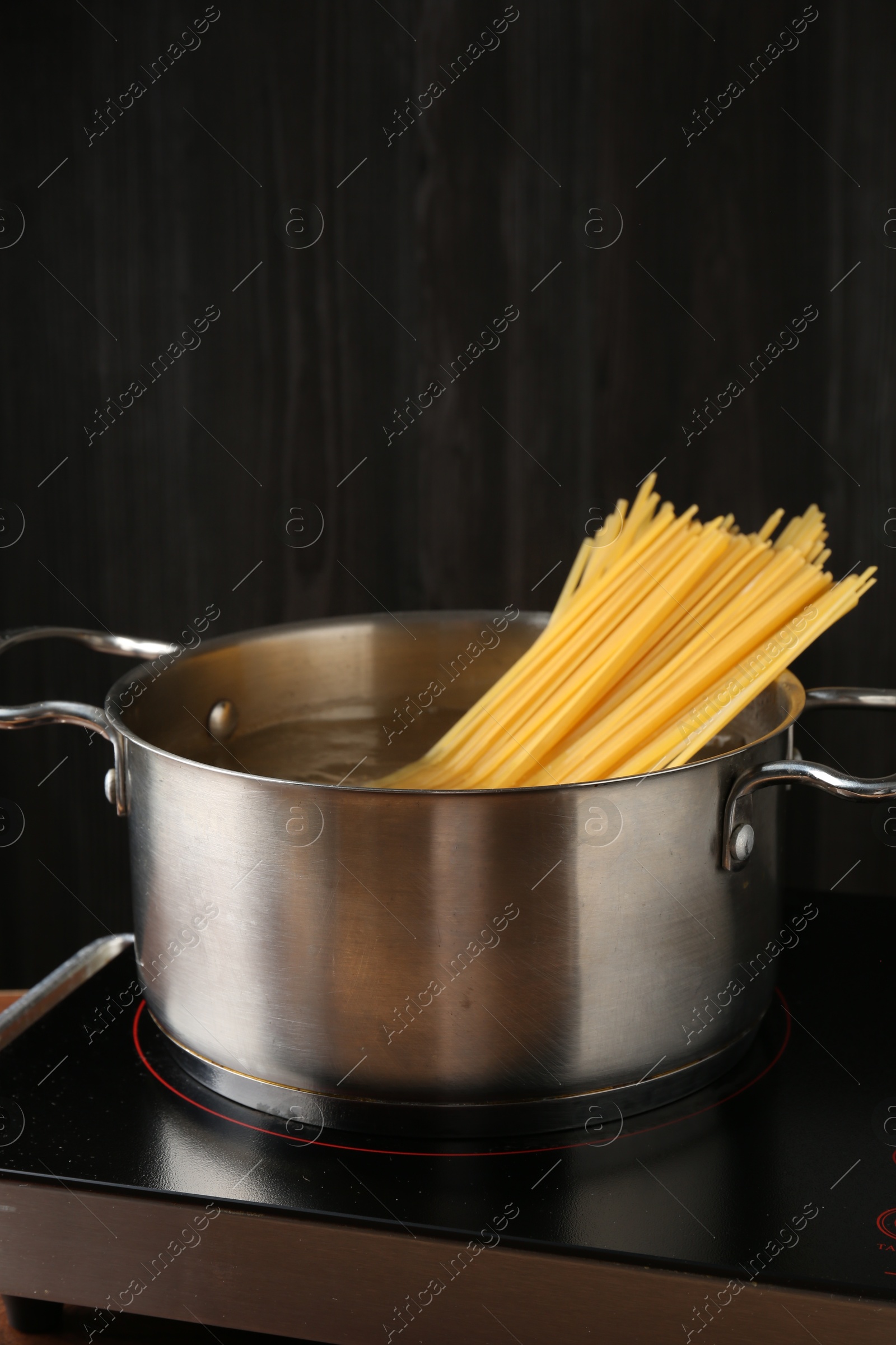 Fresh tagliatelle pasta boiling in pot with water on electric stove, closeup Photo of Fresh tagliatelle pasta boiling in pot with water on electric stove, closeup