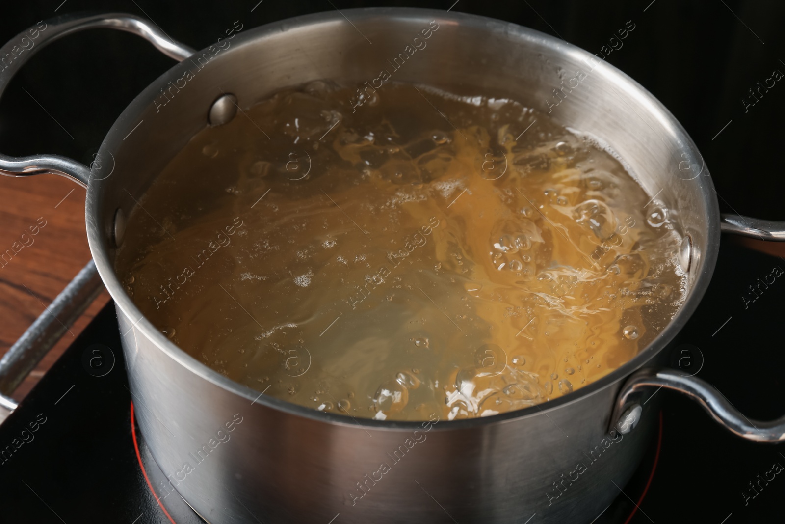 Fresh tagliatelle pasta boiling in pot with water on electric stove, closeup Photo of Fresh tagliatelle pasta boiling in pot with water on electric stove, closeup