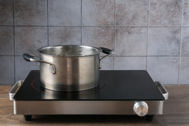 Photo of Metal pot with boiling water on stove in kitchen