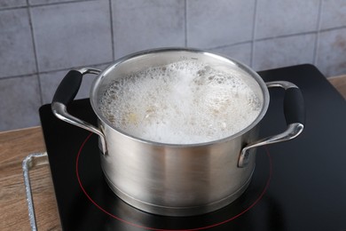 Photo of Fresh pasta boiling in pot with water on electric stove, closeup